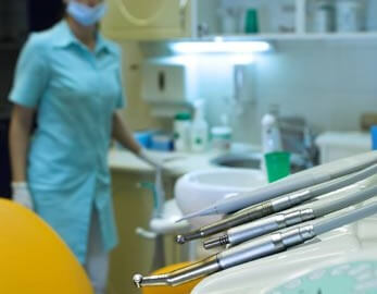 dental hygiene tools, with hygienist in background