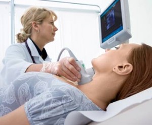 sonographer scanning a patient's thyroid