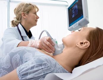 sonographer scanning a patient's thyroid