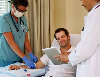 doctor and nurse consult with dialysis patient