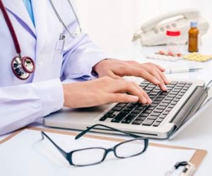 nurse types on laptop