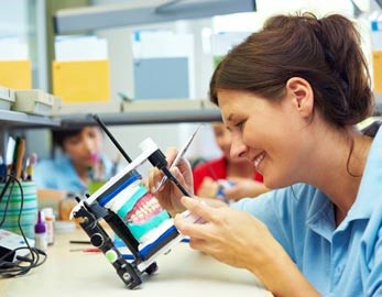 dental lab technician articulating dentures and perfecting bite