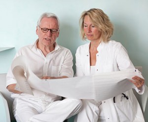 two medical professionals read electroneurodiagnostic printout