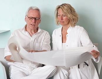 two medical professionals read electroneurodiagnostic printout