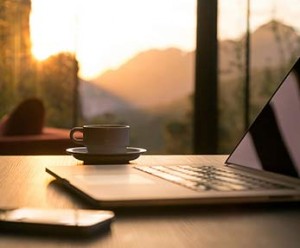 Early morning sunrise, from inside of hospital office, with laptop, coffee, phone on desk