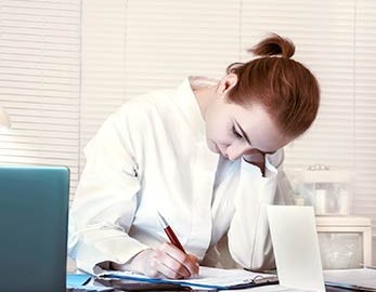 HIM student, heads down, studying, with laptop open