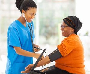 Medical assistant taking female patient's blood pressure