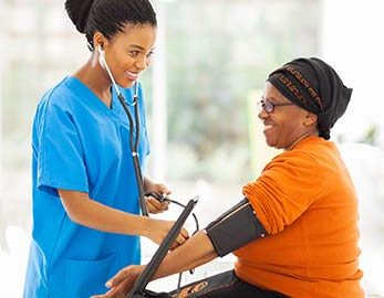 Medical assistant taking female patient's blood pressure