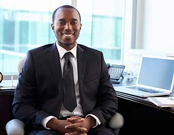 RHIT seated at desk, smiling